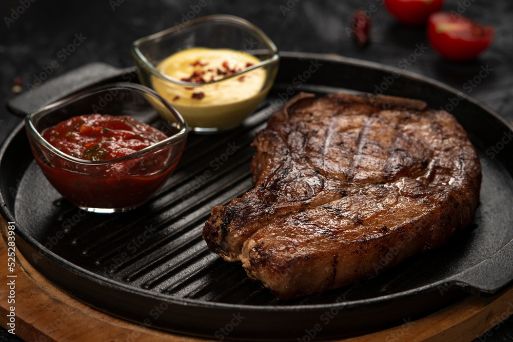 pork steak with vegetables in a black iron pan