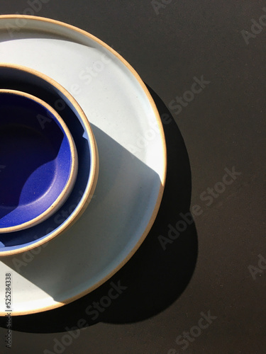 Plates and bowl of food in blue, white colors and black background, for food and decoration