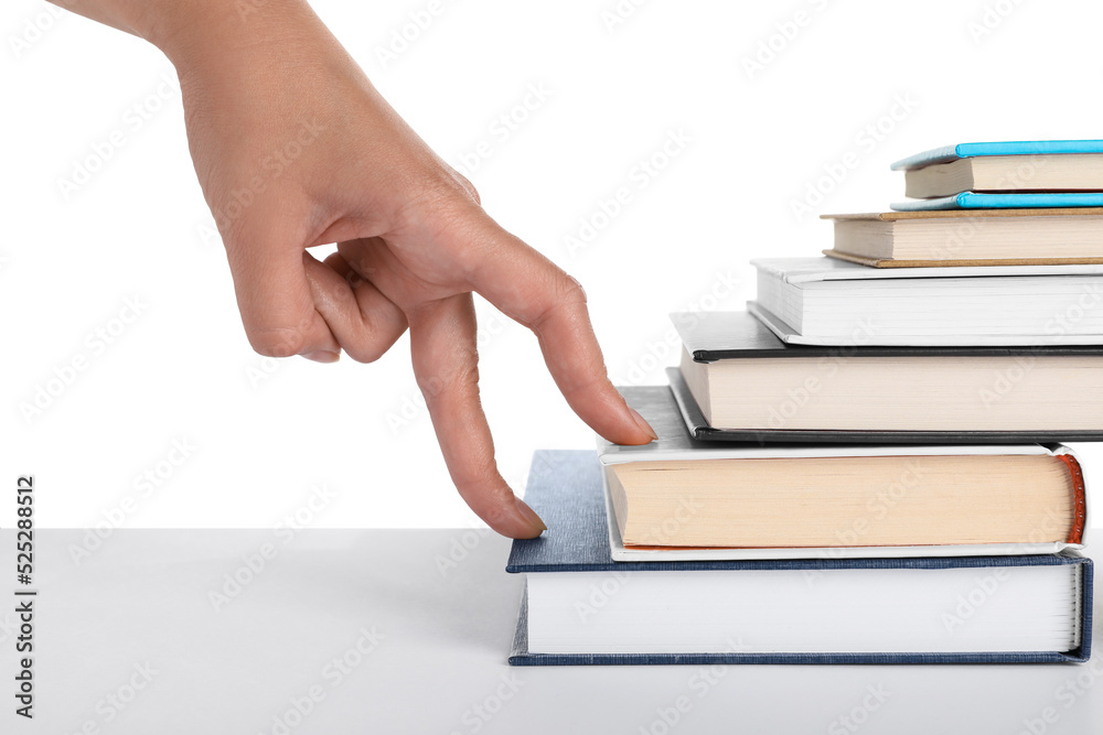 Woman imitating stepping up on books with her fingers against white background, closeup Woman imitating stepping up on books with her fingers against white background, closeup