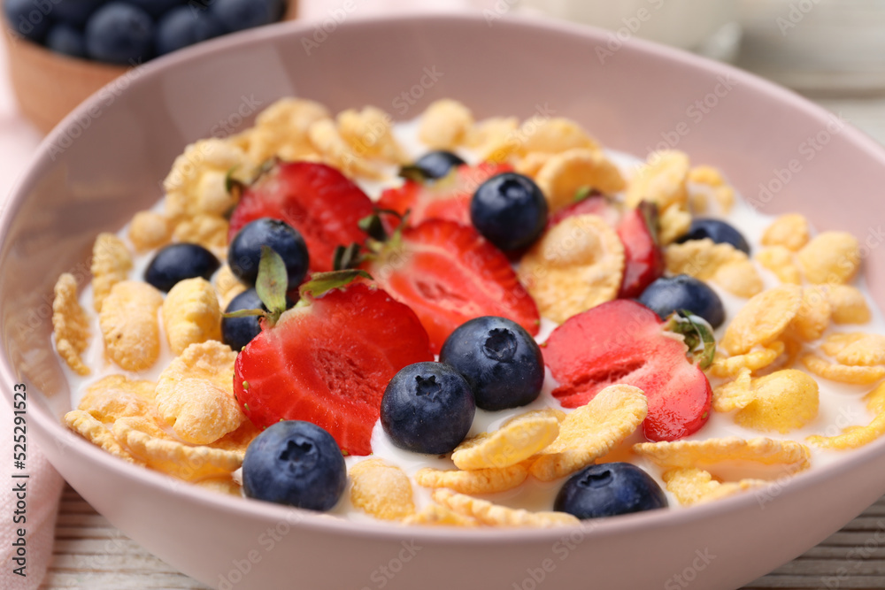Bowl of tasty crispy corn flakes with milk and berries on table, closeup Bowl of tasty crispy corn flakes with milk and berries on table, closeup