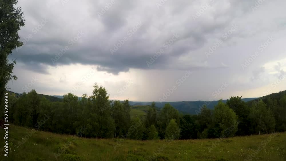Timelapse of rain clouds approaching from the horizon over a meadow surrounded by trees. Timelapse of rain clouds approaching from the horizon over a meadow surrounded by trees.