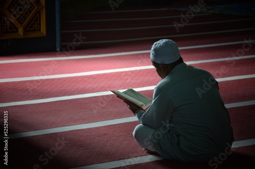 Photography An unknown person is reading the Koran with solemnity in a mosque