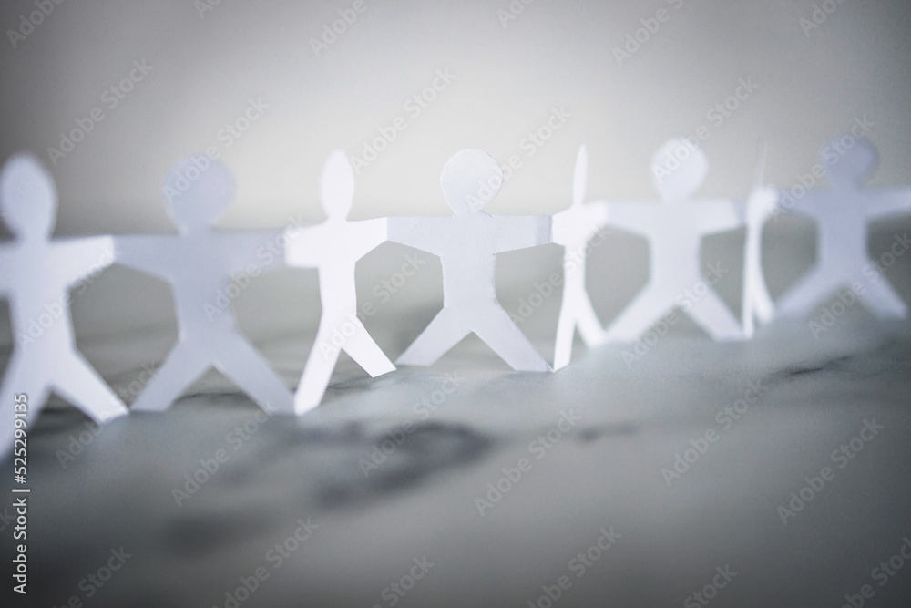 manpower and teamwork, paper people chain with text on white marble background manpower and teamwork, paper people chain with text on white marble background