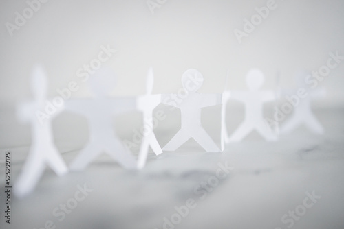 manpower and teamwork, paper people chain with text on white marble background photo