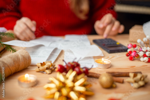 Christmas stress - counting expenses  needed for winter holidays. Many checks on the table  calculator nearby  Christmas decoration on the table