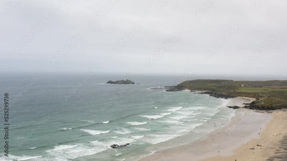 Tourist On Vacation At Godrevy Beach In St Ives Bay, Cornwall, England. Aerial Wide Shot Tourist On Vacation At Godrevy Beach In St Ives Bay, Cornwall, England. Aerial Wide Shot