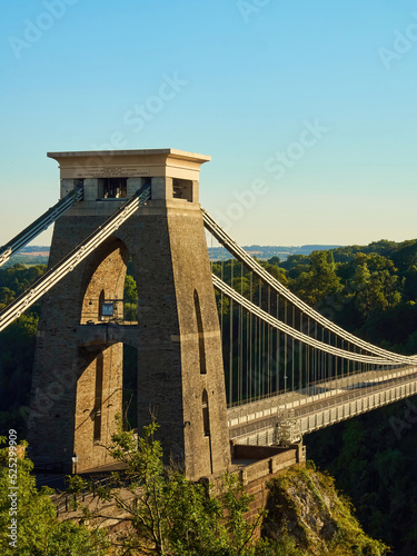 The famous Clifton Suspension Bridge at Bristol in dramatic side-lighting from a setting summer sun.