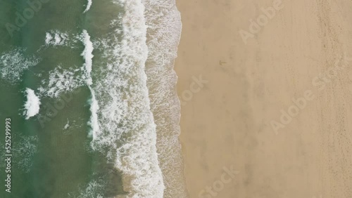 Vertical Shot Of Foamy Waves Washed Over Sandy Shore At St Ives, Cornwall, England. Aerial Shot photo