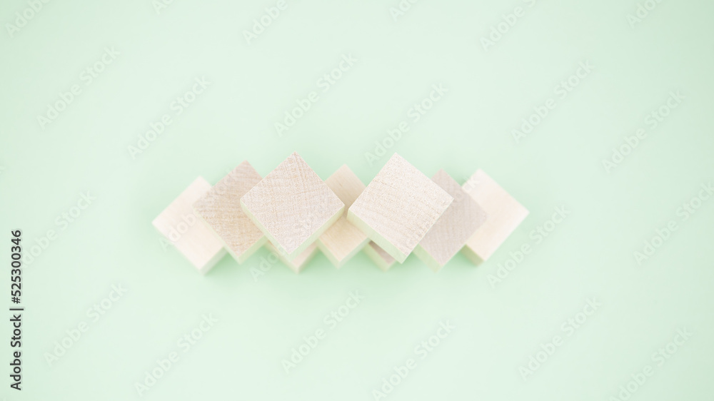 Small wooden cubes lie on a green background. Close up.