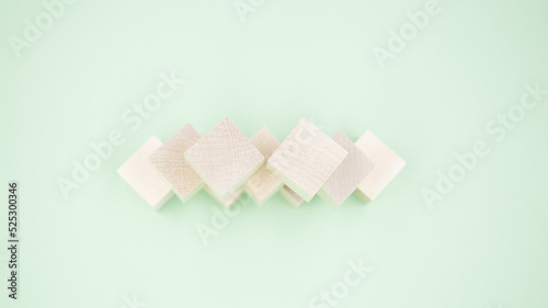 Small wooden cubes lie on a green background. Close up.