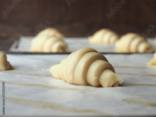 Raw mini croissants on baking paper