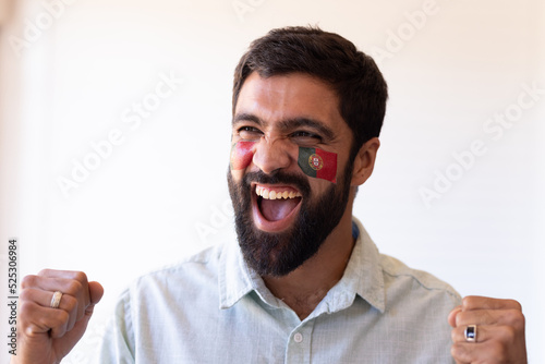 Image of happy multiracial man with flags of portugal on face