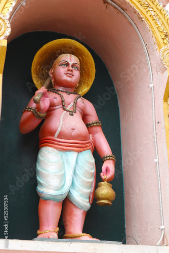 Vamanadeva or Vamana is the incarnation of Vishnu - a dwarf brahmin boy. Avatar of an Indian god on the wall of a Hindu temple. photo