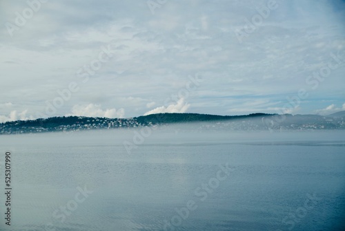 blue sky with clouds, fog, mountains and sea 