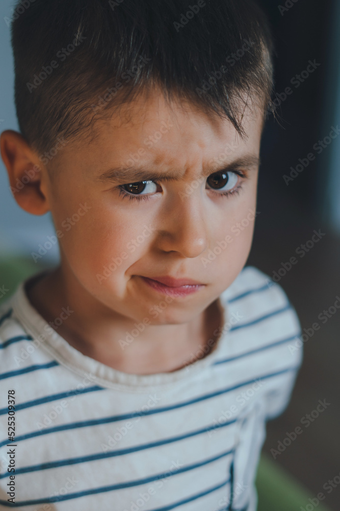 Child grimaces while standing at home, posing looking at camera. Childhood concept. People emotions lifestyle concept. Closeup portrait. Child grimaces while standing at home, posing looking at camera. Childhood concept. People emotions lifestyle concept. Closeup portrait.