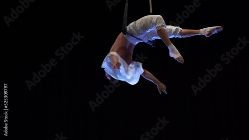 Muscular male air circus artist performances with dance trapeze 