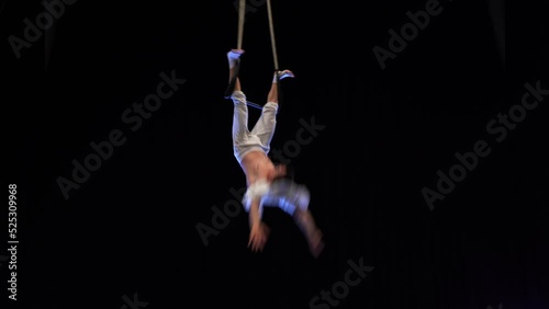 Muscular male air circus artist performances with dance trapeze 