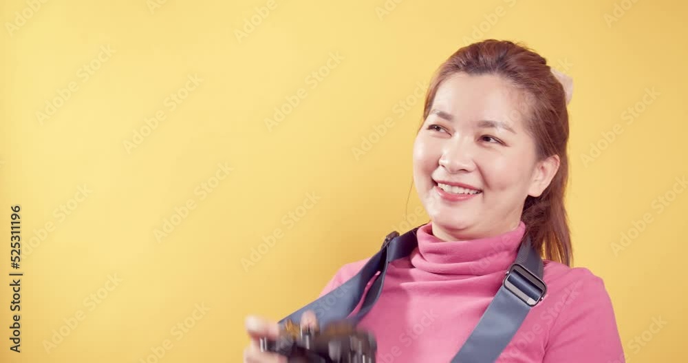 Smart Happy delighted an Asian woman with a digital camera and isolated yellow background. Travel concept. Smart Happy delighted an Asian woman with a digital camera and isolated yellow background. Travel concept.