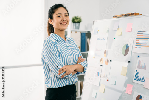 Fotografie confident asian businesswoman standing by whiteboard with graphs and charts in s