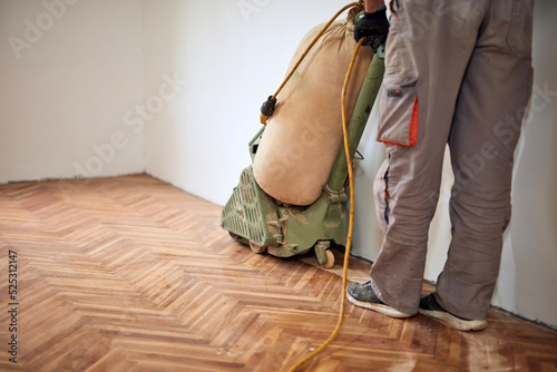 Принти на полотні Repairman restoring parquet with a sanding machine.