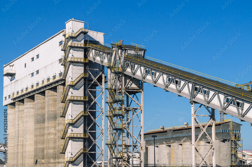 Conveyor gallery at the oil refinery. Installation of coke shipment at a petrochemical plant. Silo shipment unit. Production of deep oil refining. Technological buildings at the factory.