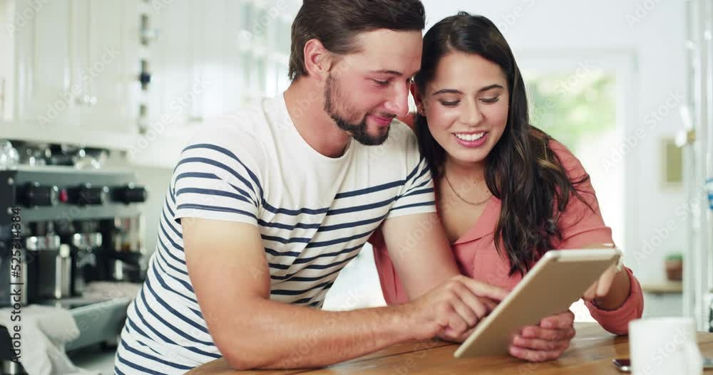 Online, 5g internet and social media content of a couple doing a web search on a digital tablet. Happy, laughing and in love young man and woman on modern technology with a smile in a home kitchen Online, 5g internet and social media content of a couple doing a web search on a digital tablet. Happy, laughing and in love young man and woman on modern technology with a smile in a home kitchen