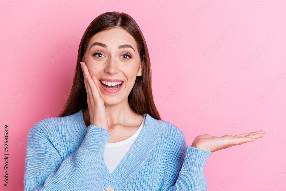 Photo of impressed excited stylish toothy girl staring open mouth holding hand on cheek another hand show empty space isolated on pink background Photo of impressed excited stylish toothy girl staring open mouth holding hand on cheek another hand show empty space isolated on pink background