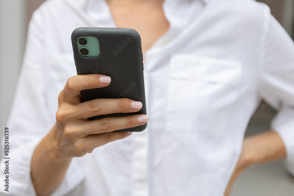 female hands hold a modern mobile phone on the street..education, modern app, shopping order, work online