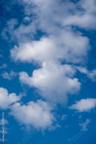Natural sunny blue sky background with beautiful puffy white cumulus clouds