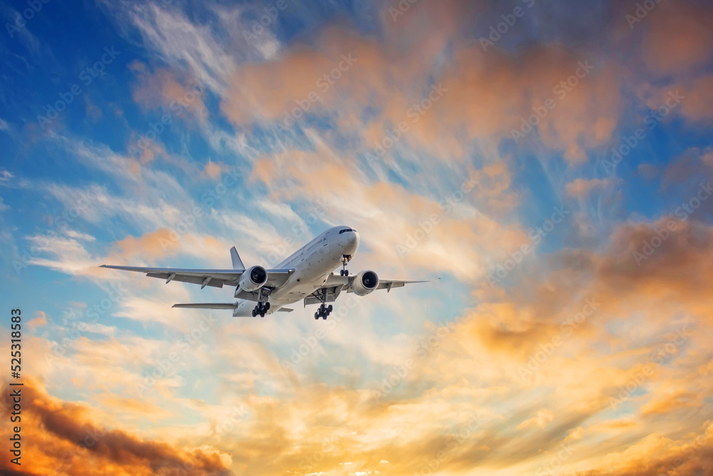 Airliner in the sky with extended landing gear against amazing sky.