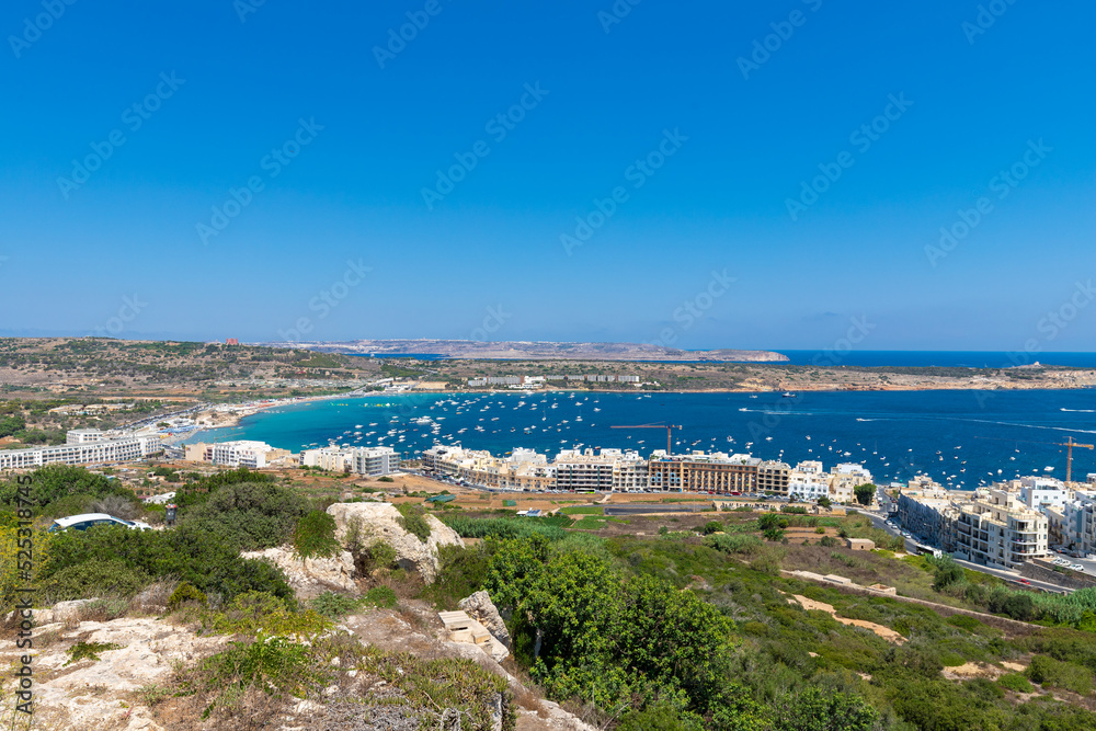 a view on the bay of Mellieha, Malta seen from a viewpoint. It gives a perfect view on the resorts, boats and the turquoise blue water