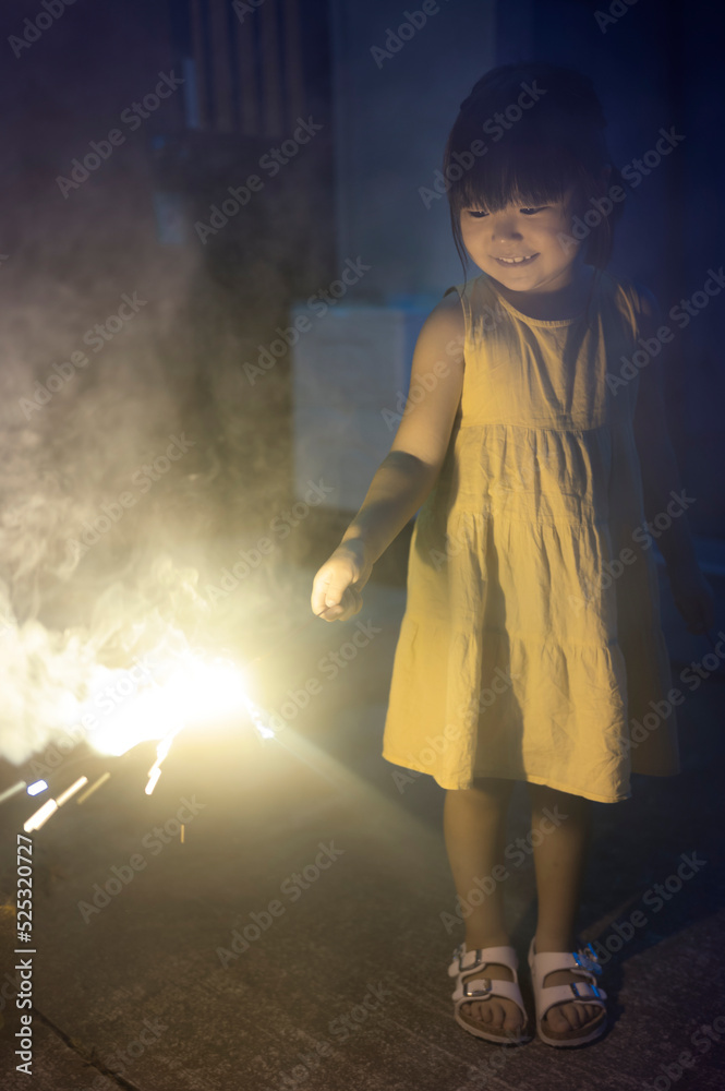 夏休みに家族と手持ち花火を持って遊ぶ女の子