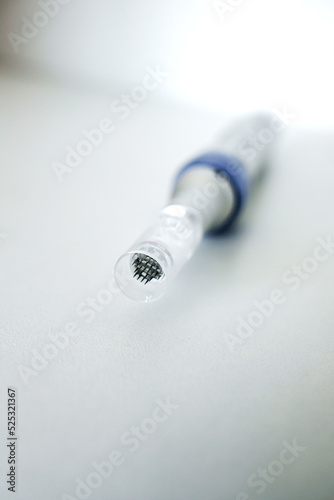 Microneedles for collagen induction therapy. Apparatus with needles close-up on grey background. Vertical photo photo