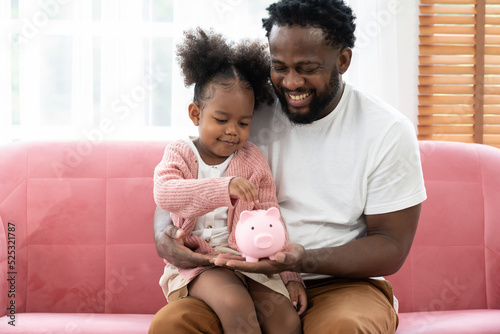 Принти на полотні Father and daughter inserting a coin in a piggy bank