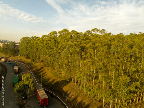 Foto aérea, da chegada das carretas para carregamento e descarregamento com  floresta de reflorestamento, com eucaliptus ao fundo em Limeira, São Paulo, Brasil photo