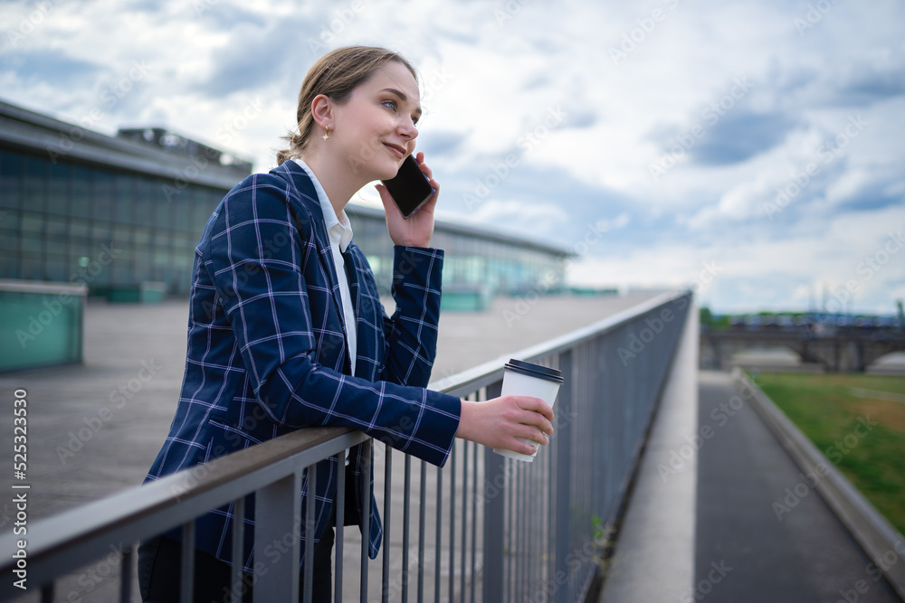 Businesswoman speaking on smartphone on embankment Businesswoman speaking on smartphone on embankment