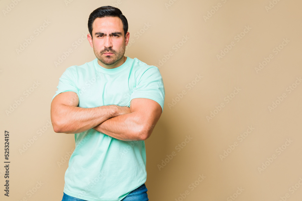 Man in casual clothing looking angry and frowning in a studio Man in casual clothing looking angry and frowning in a studio
