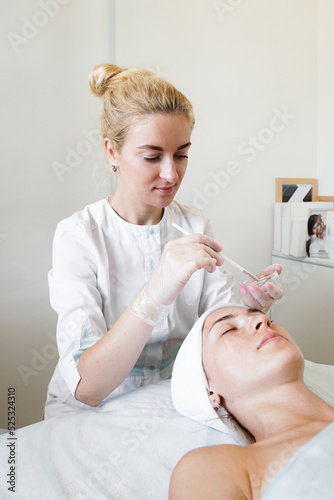 Microneedles for collagen induction therapy. Microneedle RF lifting. Procedure for beauty and rejuvenation. Young woman in a beauty salon photo