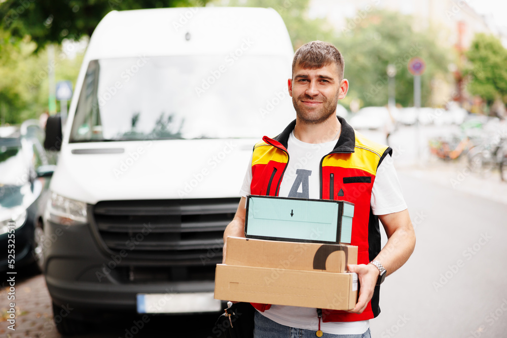 Deliveries are right on schedule. Portrait of a smiling delivery man standing in front of his