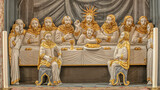 the disciples carved as golden figures sit at the table with Jesus at the Last Supper