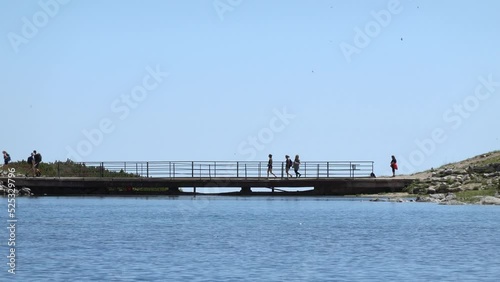 Tourists cross the bridge over Skalnate Lake in the High Tatras in Slovakia photo