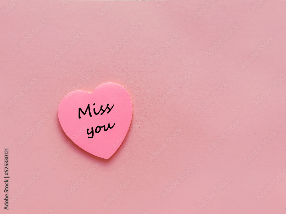 Miss you  written on  pink sticky note in  heart  shape  