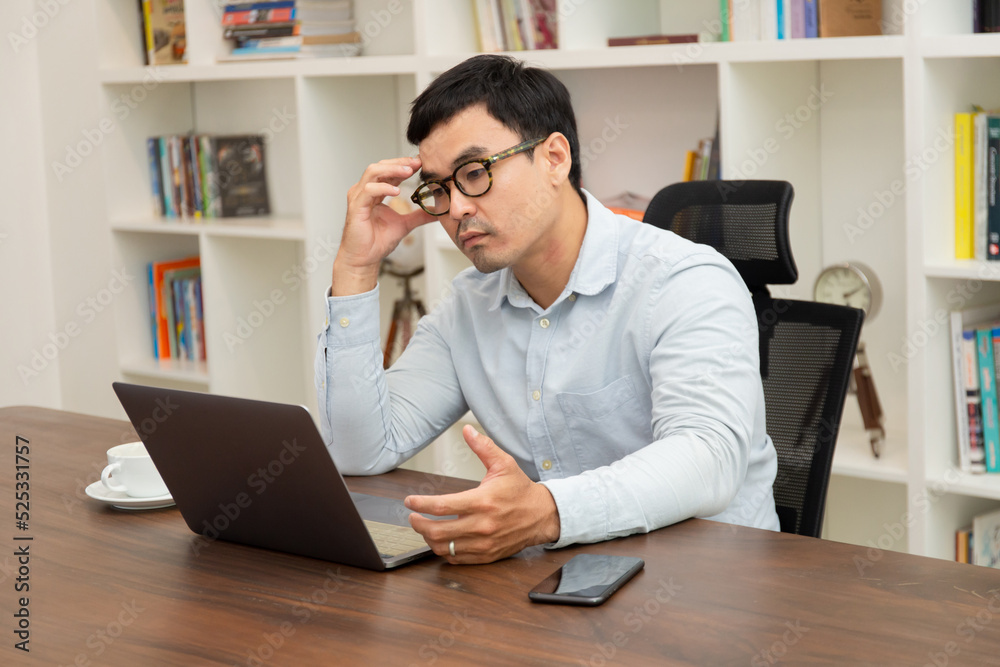sad depression serious people from work,study stress problem.asian man feeling tired suffering using computer working work place.concept global economic,health problems sad depression serious people from work,study stress problem.asian man feeling tired suffering using computer working work place.concept global economic,health problems