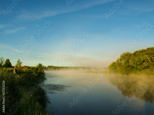 Sunrise over a foggy lake. early morning on the river. sunrise and mist over water and trees with reflections on the river bank.