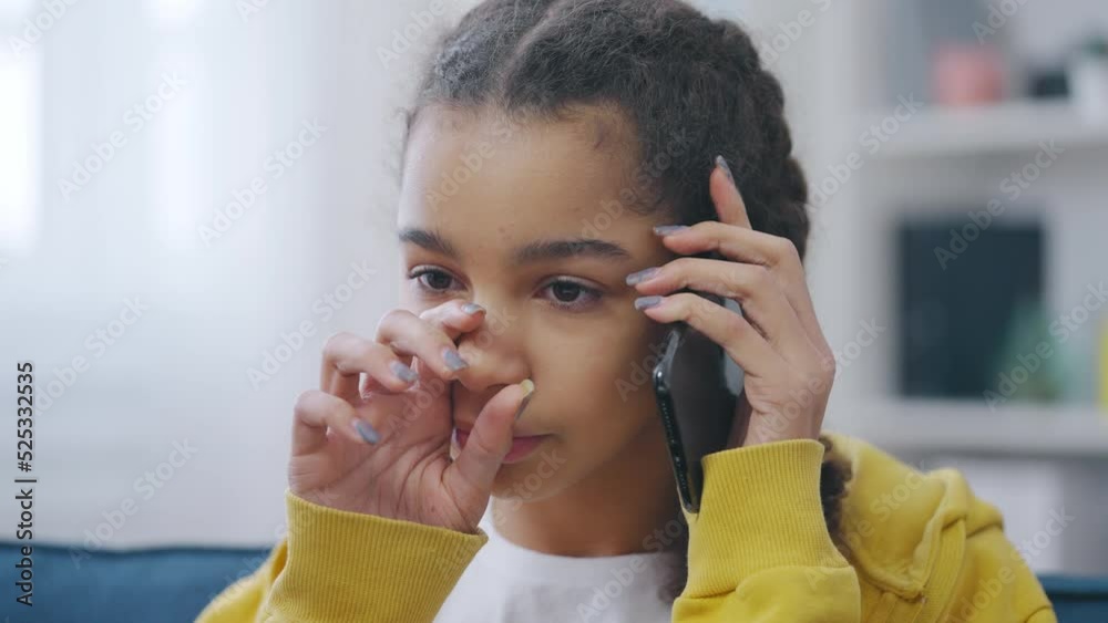 Depressed teen girl crying while talking on mobile phone, bad news or problems Depressed teen girl crying while talking on mobile phone, bad news or problems