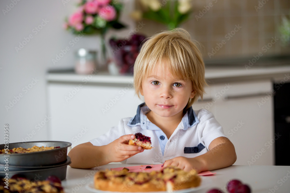 Cute little toddler child, eating homemade plum pie at home Cute little toddler child, eating homemade plum pie at home