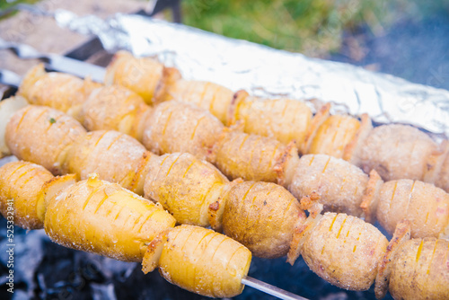 Whole potatoes in a rustic way on skewers. A delicious snack for a summer party with an outdoor barbecue or a picnic.Homemade food. Vegetarianism.