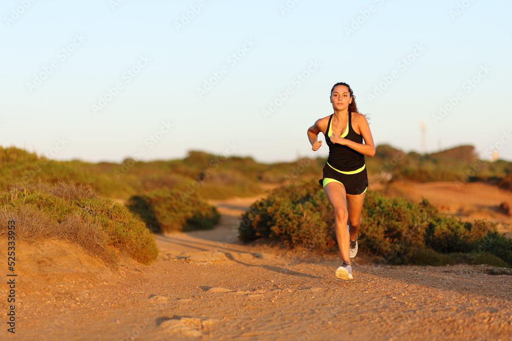 Runner woman running at sunset in the mountain