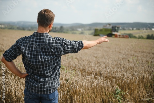 Фотография Farmer In Wheat Field Inspecting Crop