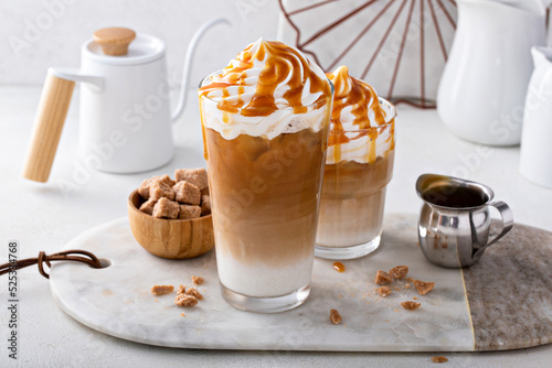 Фотография Iced caramel latte topped with whipped cream and caramel sauce